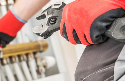 Closeup of gloved hand holding wrench and adjusting tubes